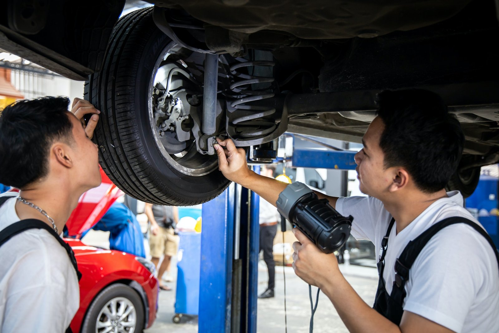 two-mechanic-was-checking-the-car-suspension-